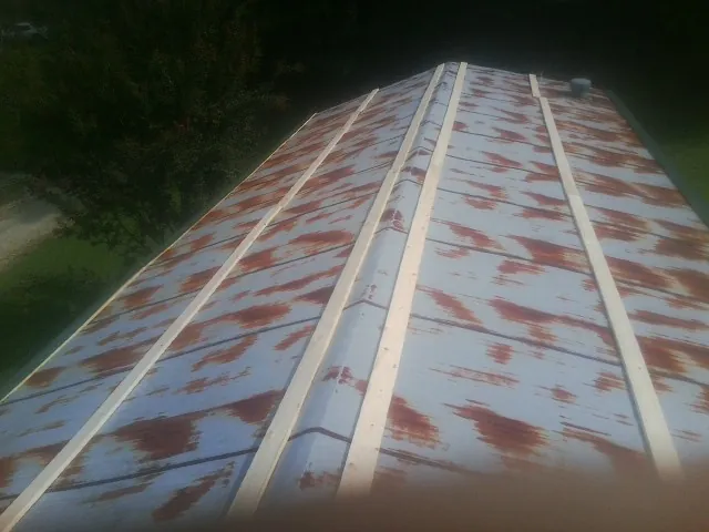 Rusted metal roof panels with new wood purlins before replacement — Storm Damage Roof Repair in Bardolph by Roofing Brothers