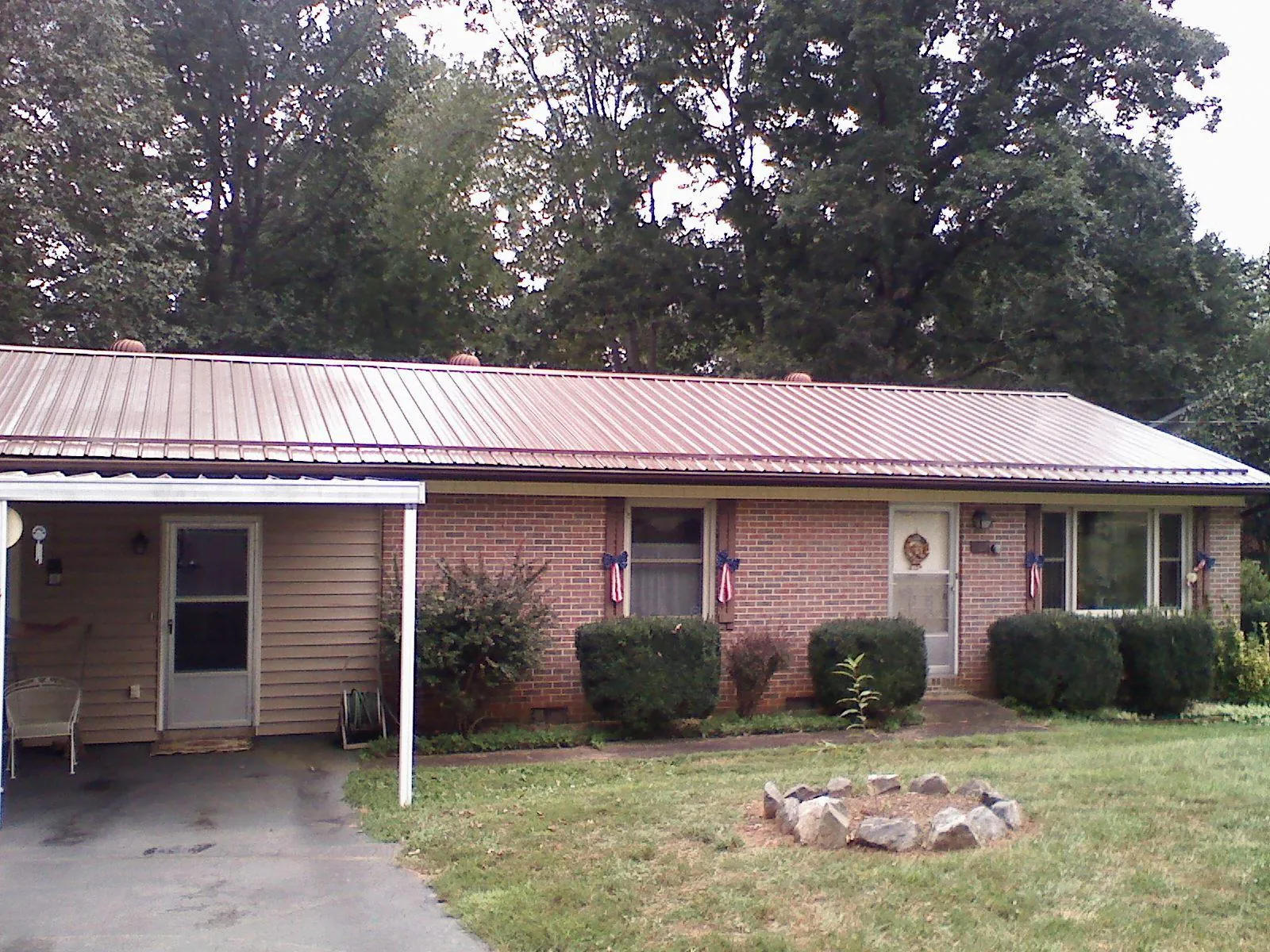 Bronze metal roof and carport on a brick ranch home — Roof Repair work by our crew in Bardolph